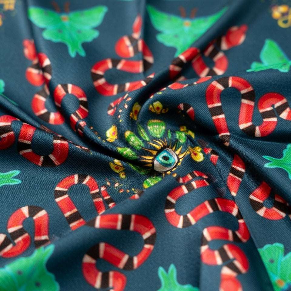 Fabric with snake and butterfly pattern on a dark blue background