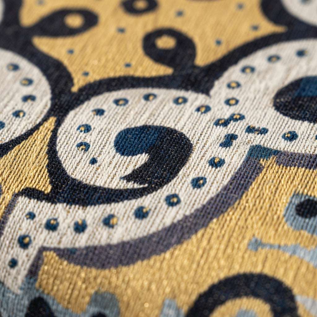 Close-up of a patterned fabric with blue, yellow, and gray colors.