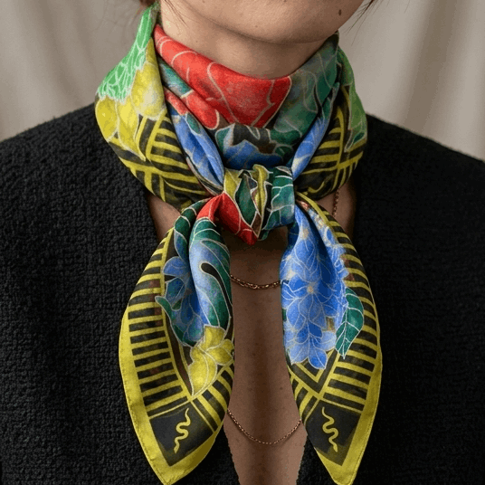 Woman wearing a colorful scarf with a neutral background