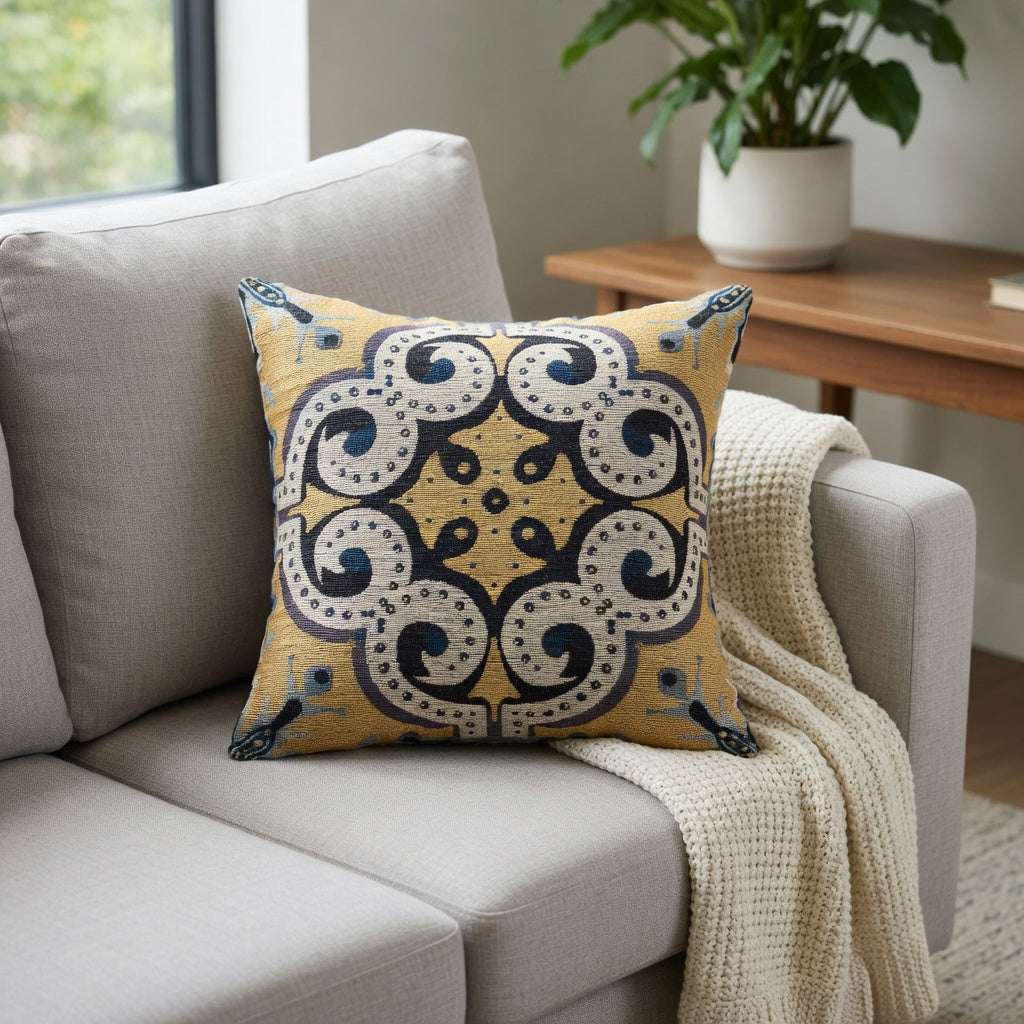 Decorative pillow with a yellow and blue pattern on a gray sofa in a living room setting.