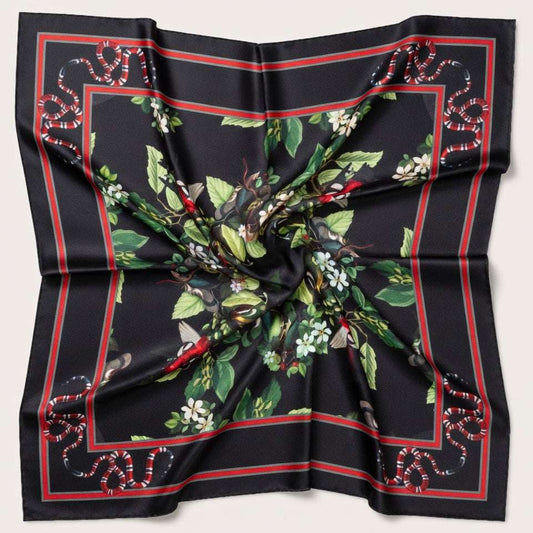 Black silk scarf with green floral and red border design on a light gray background