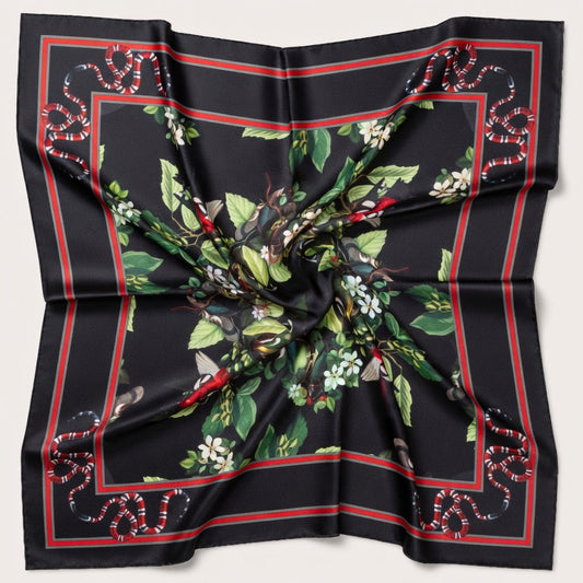 Black silk scarf with green floral and red border design on a light gray background